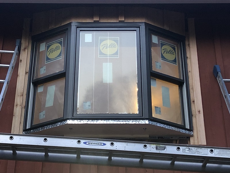 Cedar trim being installed around a Pella Lifestyles bay window in Stamford,CT
